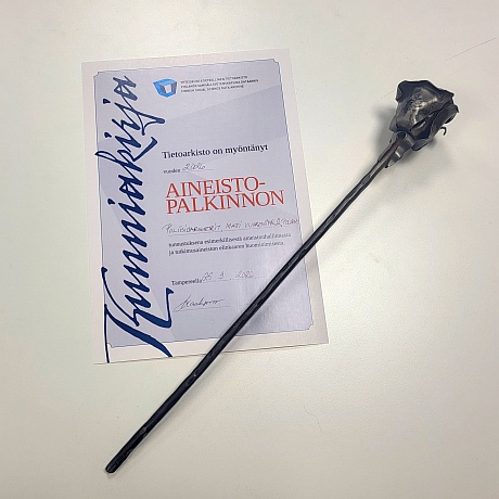 Kunniakirja, jonka päällä metallinen taottu ruusu.