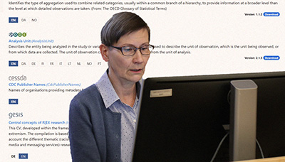 Taina Jääskeläinen sits behind of the computer screen. A graphical user interface is projected onto the background.